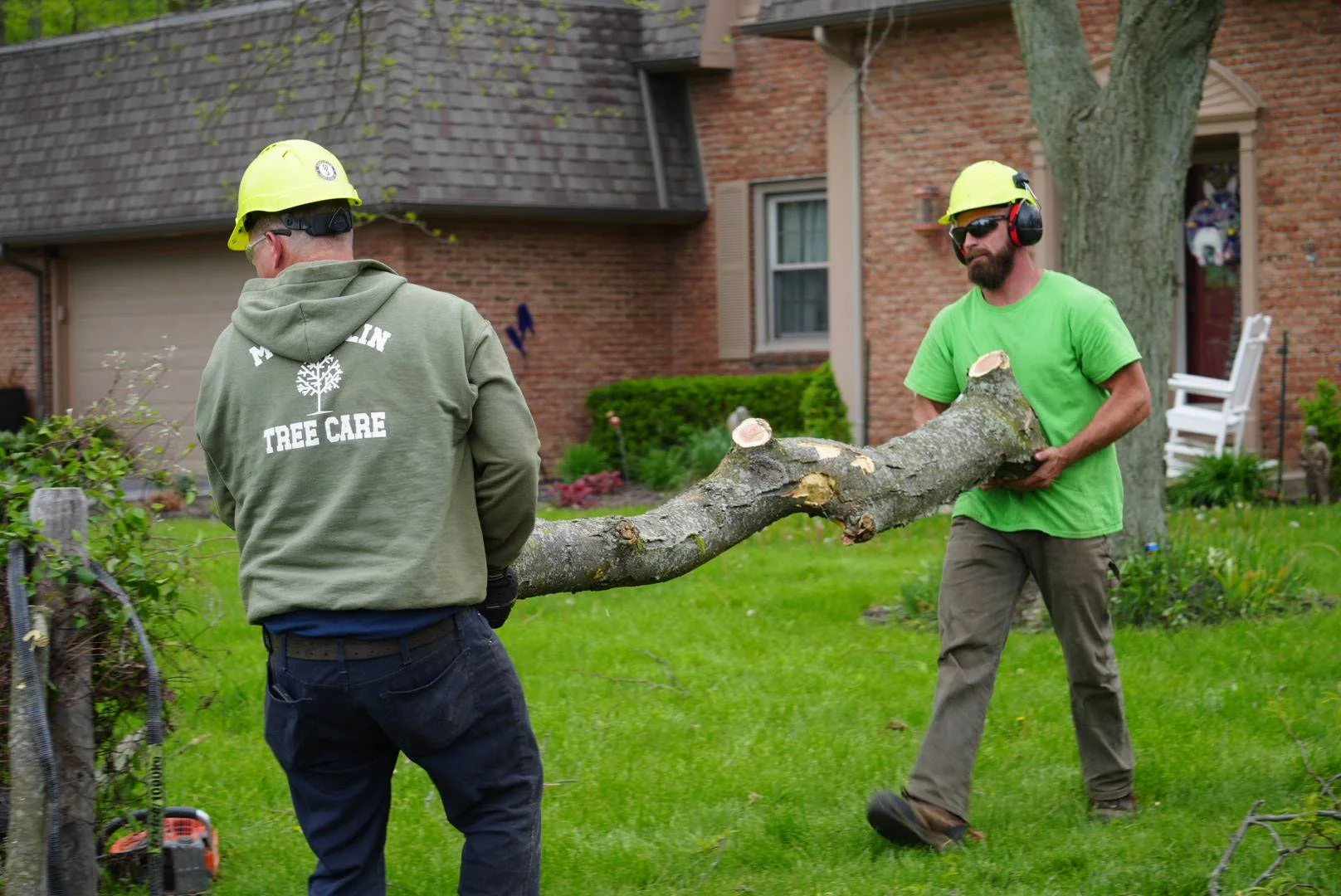McQuillin Tree Care crew carrying a tree log on a Northwest Ohio job site